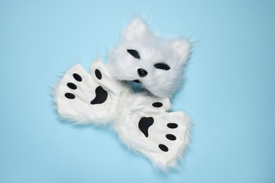 Photo of Quadrobics. Cat mask and gloves on light blue background, top view