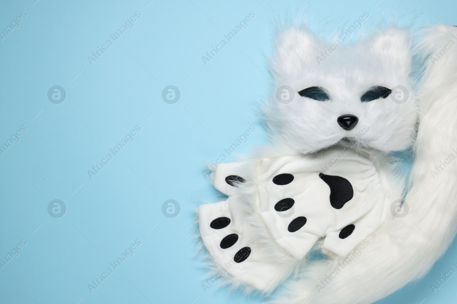 Photo of Quadrobics. Cat mask, tail and gloves on light blue background, top view. Space for text