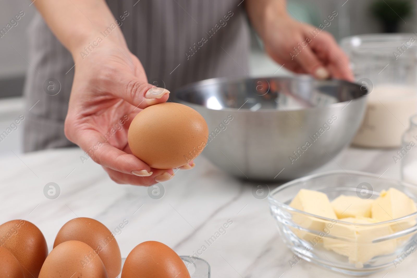 Photo of Making dough. Woman with fresh eggs at white marble table, closeup