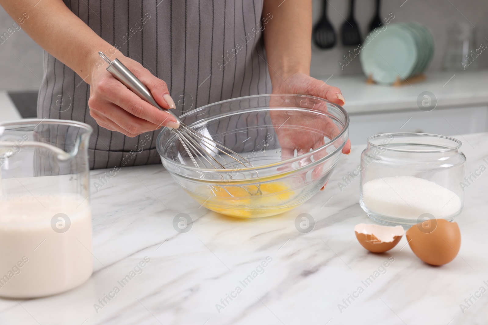 Photo of Woman making dough at white marble table indoors, closeup