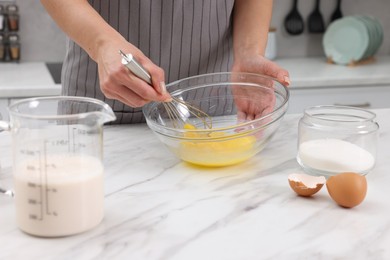 Photo of Woman making dough at white marble table indoors, closeup