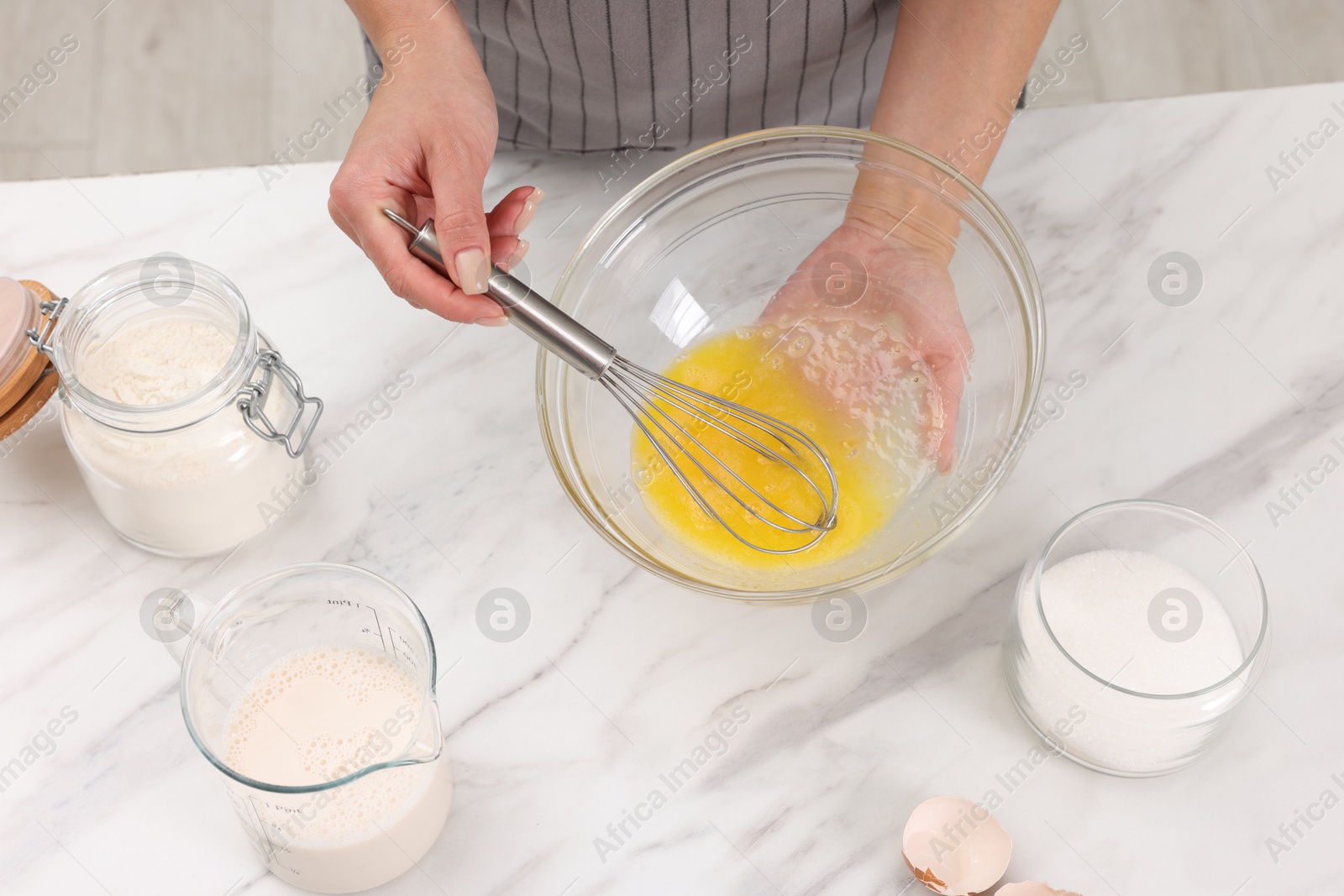 Photo of Woman making dough at white marble table indoors, above view