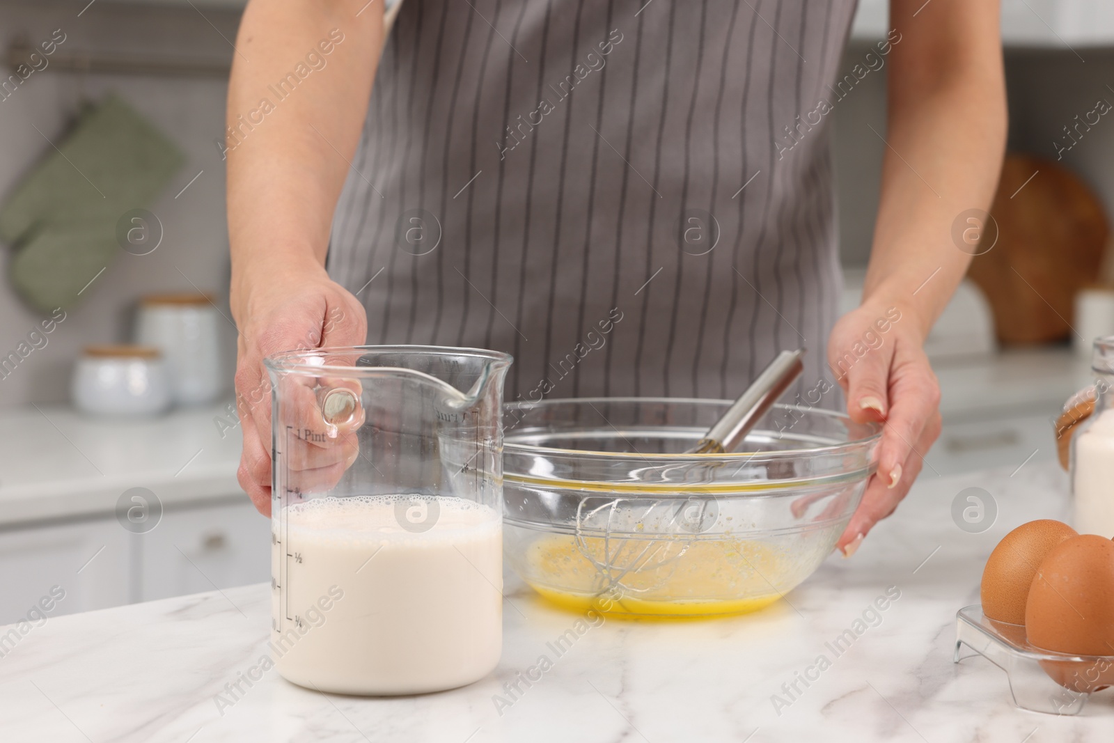 Photo of Woman making dough at white marble table indoors, closeup