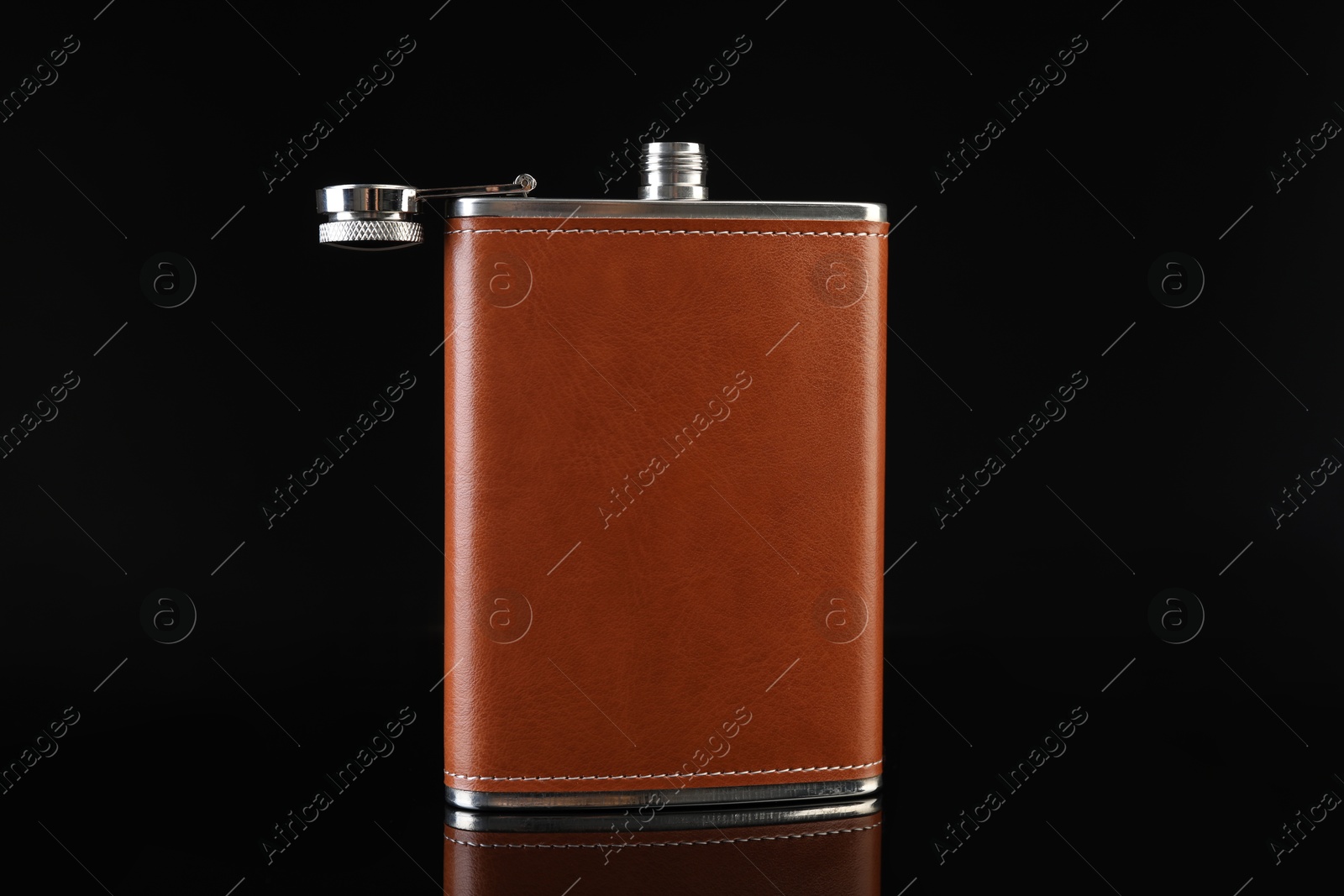 Photo of Leather hip flask on black mirror surface