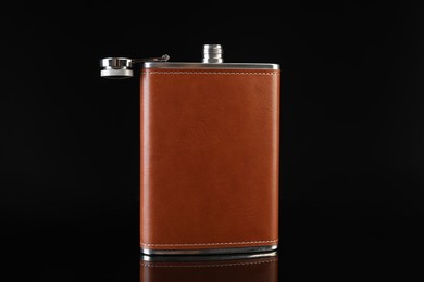 Photo of Leather hip flask on black mirror surface