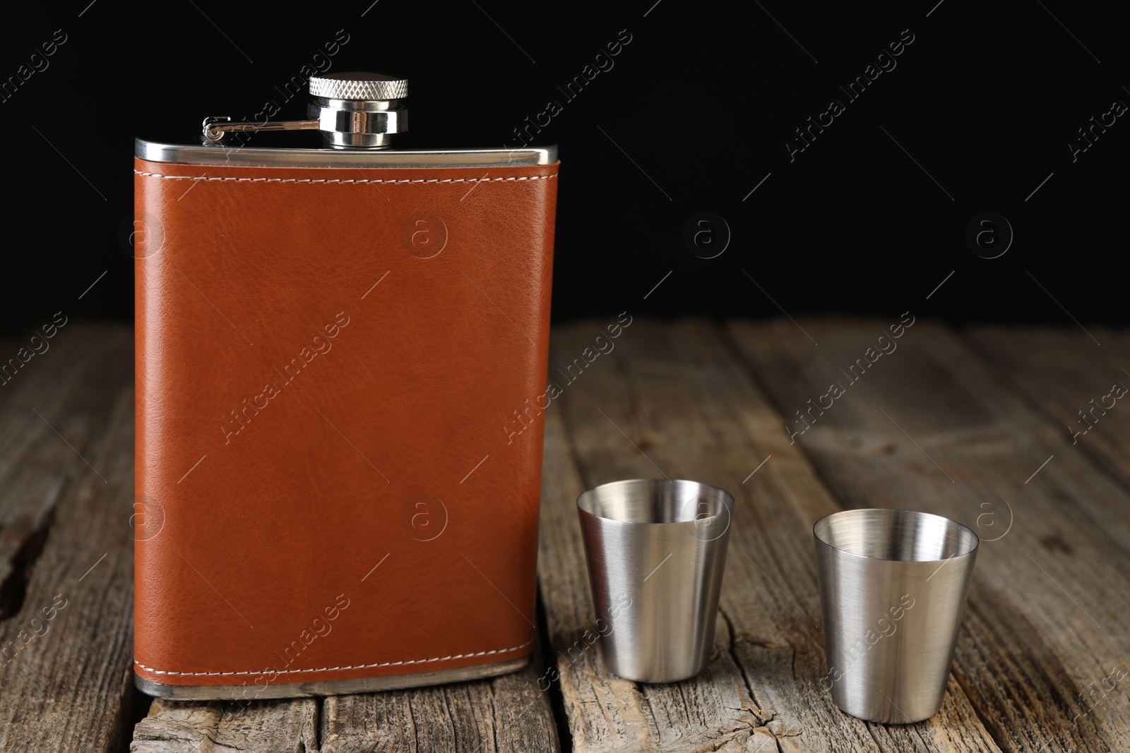 Photo of Hip flask and cups on wooden table