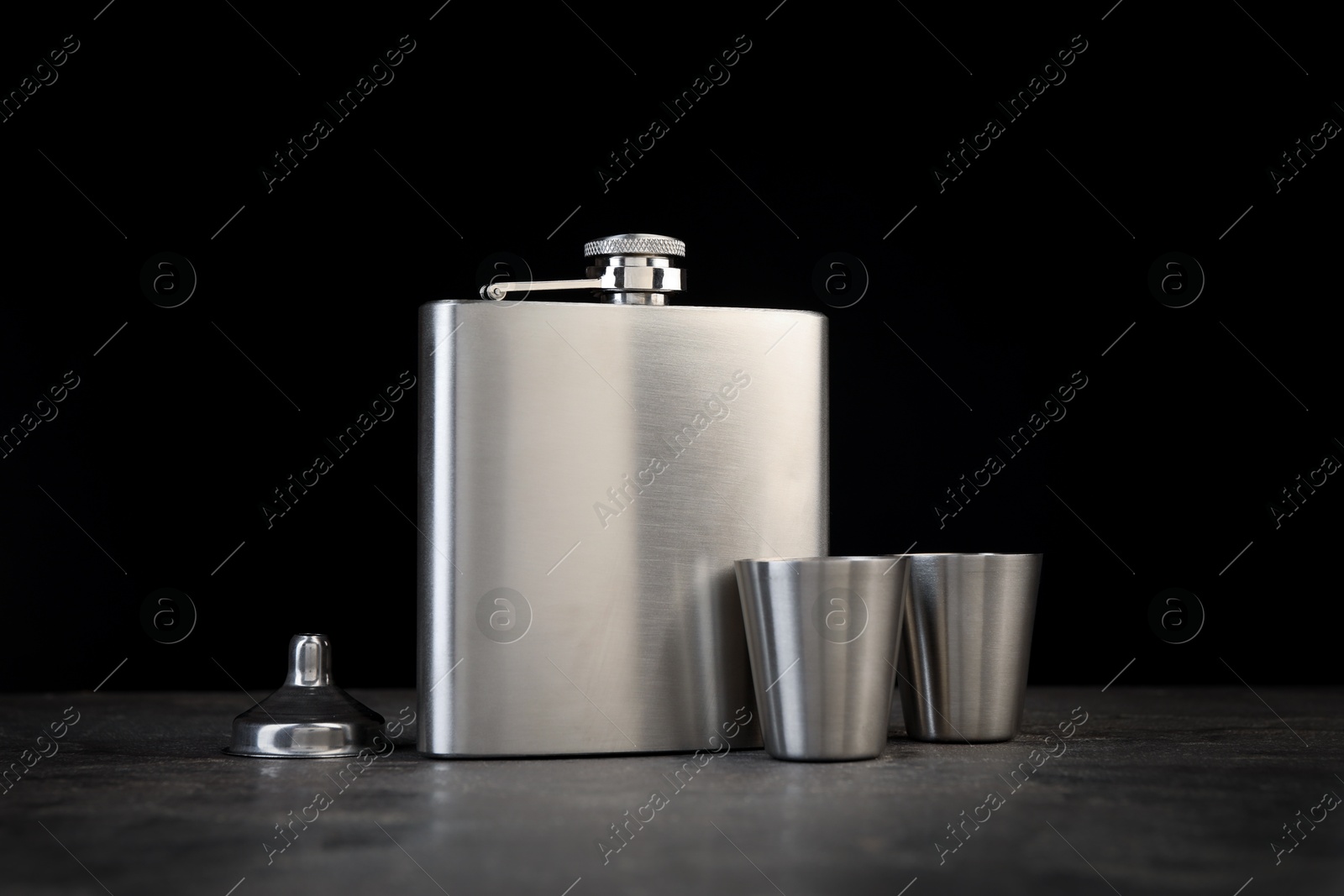 Photo of Hip flask, cups and funnel on grey table