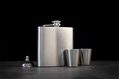 Photo of Hip flask, cups and funnel on grey table