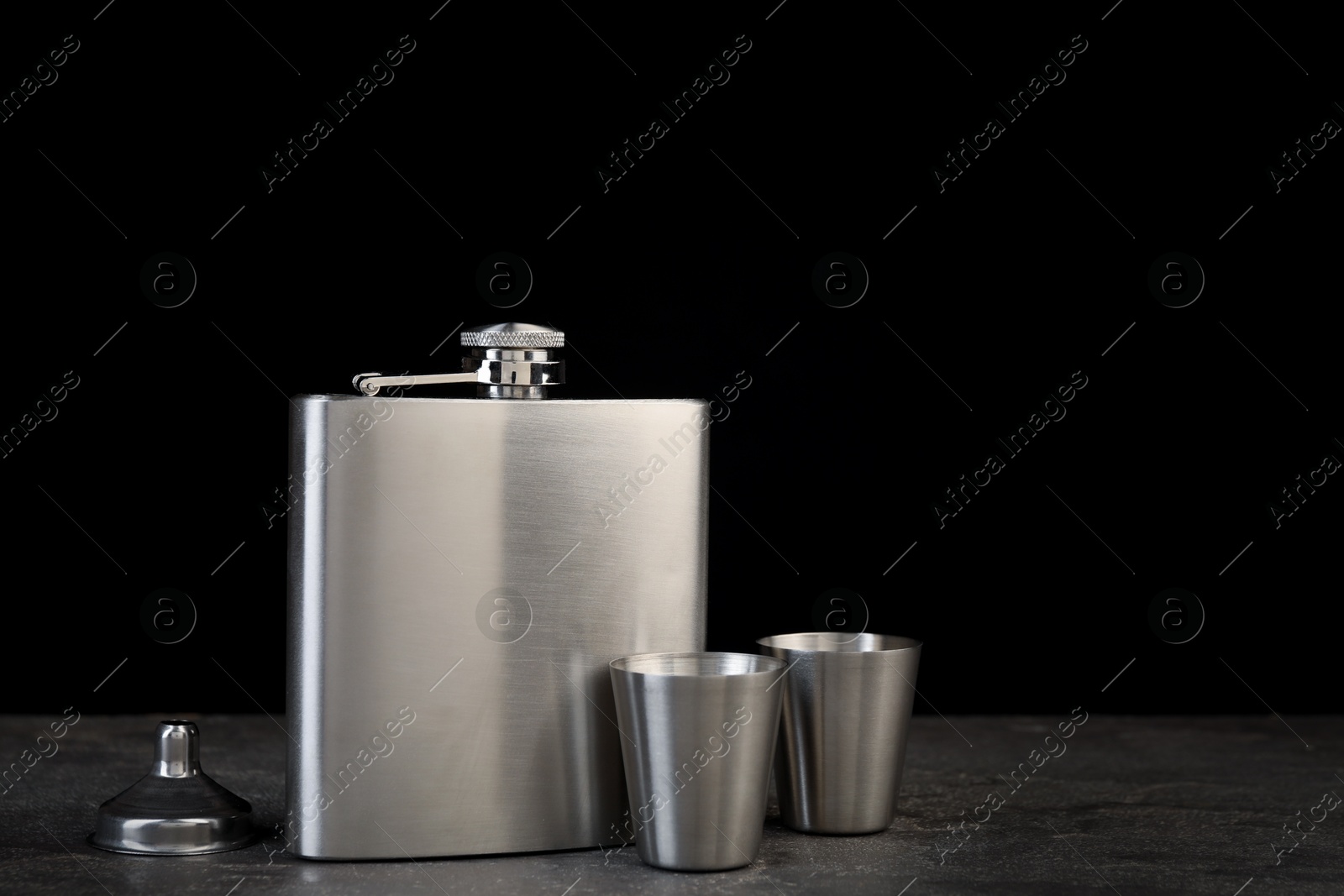 Photo of Hip flask, cups and funnel on grey table, space for text