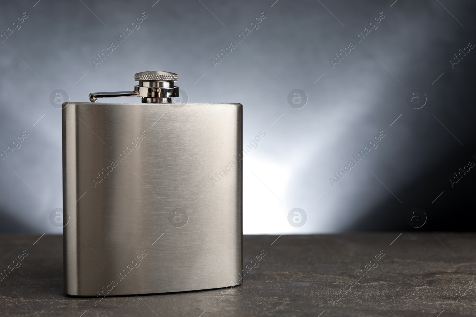 Photo of One hip flask on grey table, space for text