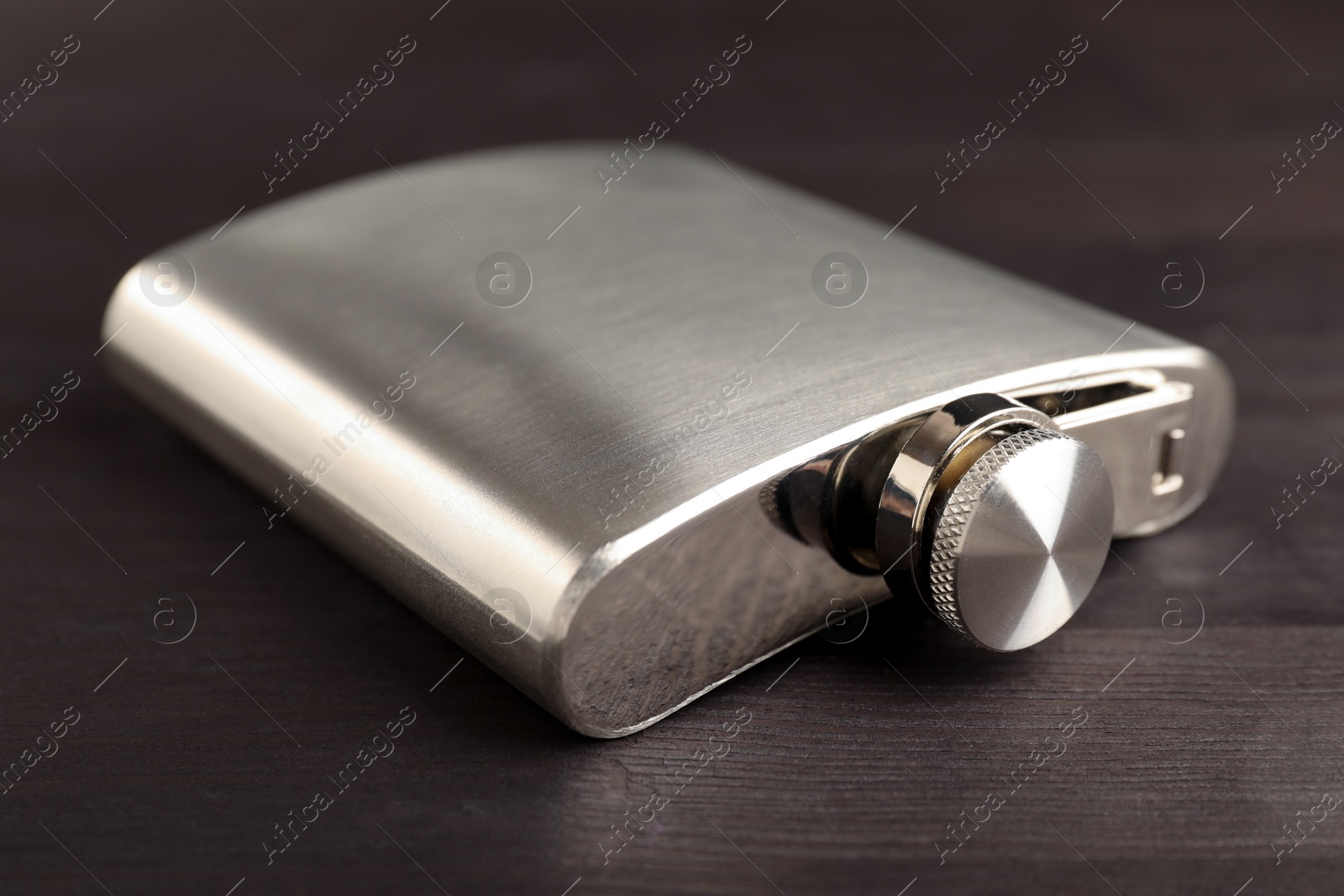 Photo of One hip flask on wooden table, closeup