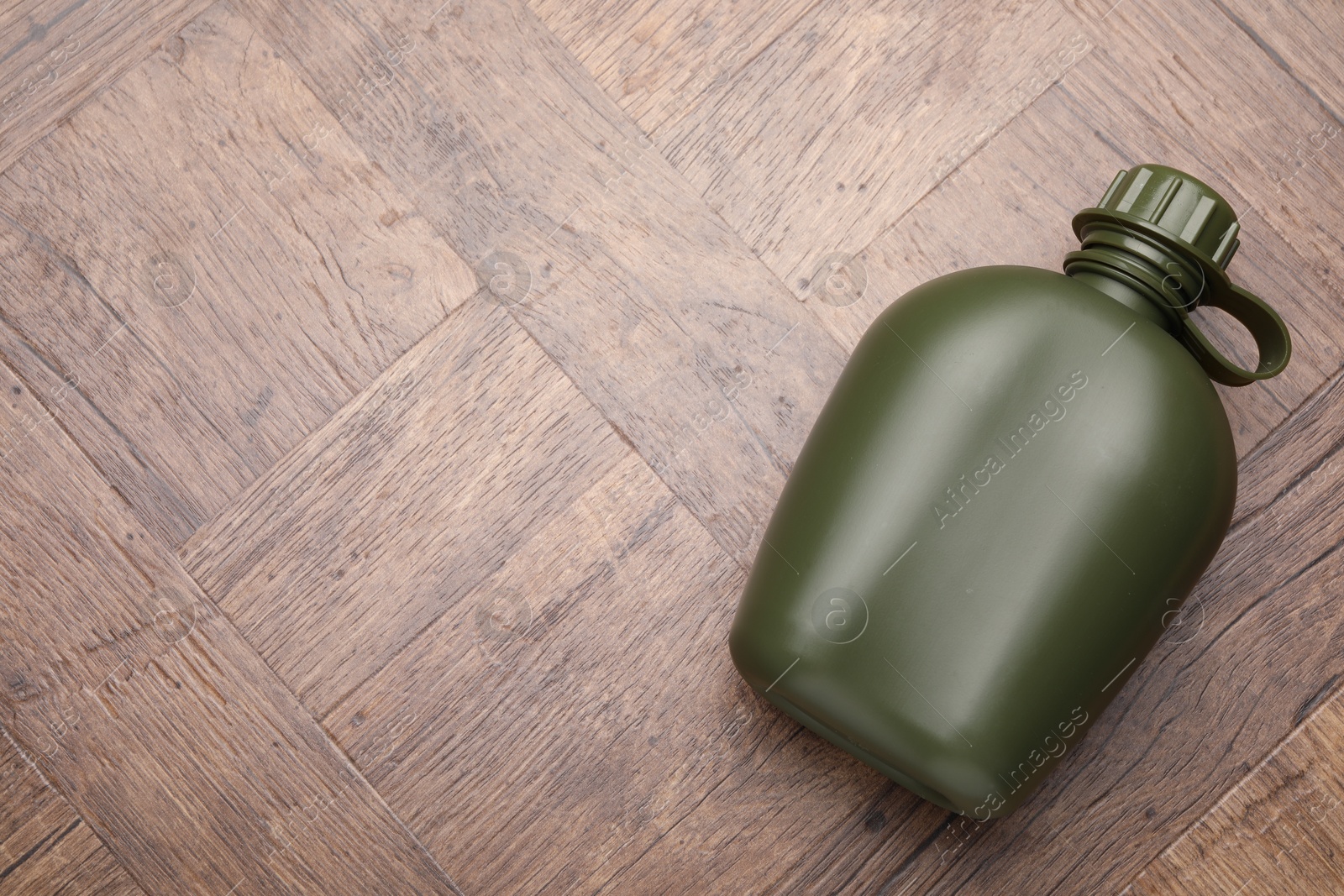 Photo of Green plastic canteen on wooden table, top view. Space for text