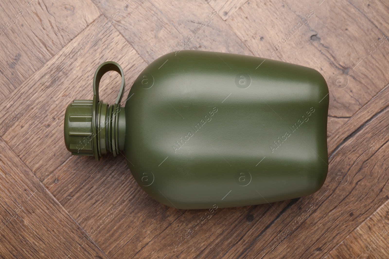 Photo of Green plastic canteen on wooden table, top view