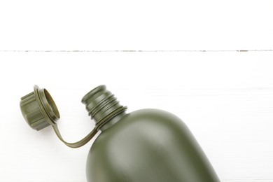 Photo of Green plastic canteen on white wooden table, top view. Space for text