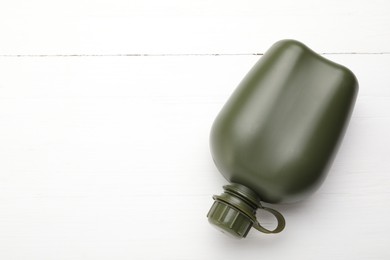 Photo of Green plastic canteen on white wooden table, top view. Space for text