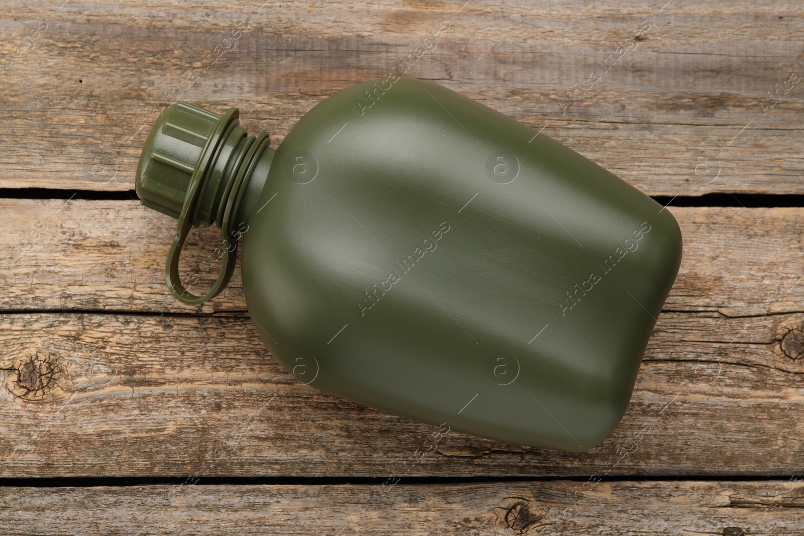 Photo of Green plastic canteen on wooden table, top view