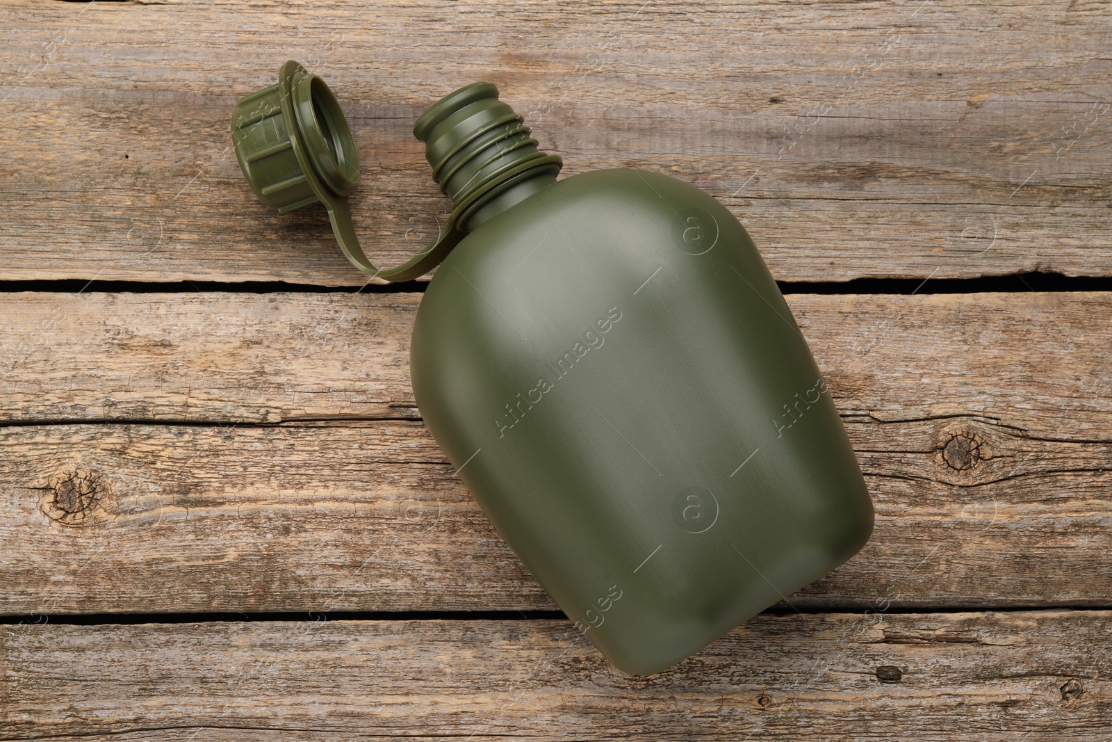 Photo of Green plastic canteen on wooden table, top view