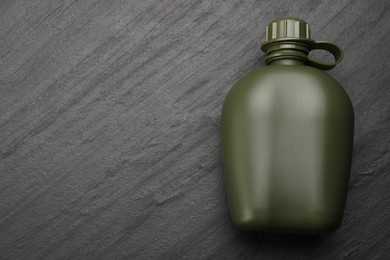 Photo of Green plastic canteen on black table, top view. Space for text