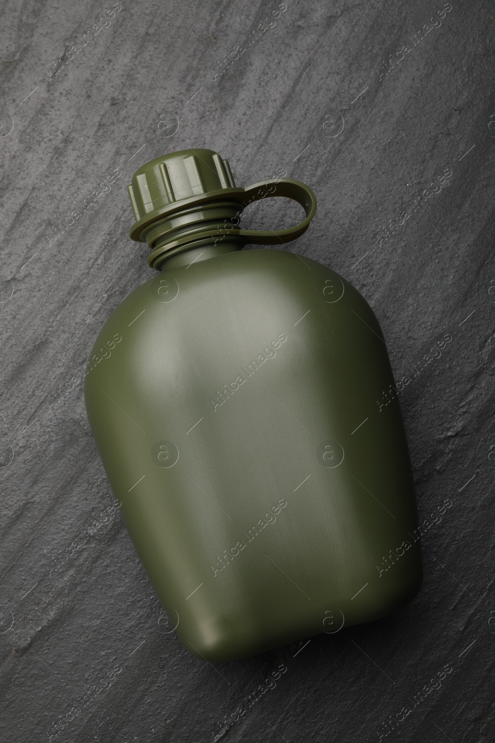 Photo of Green plastic canteen on black table, top view