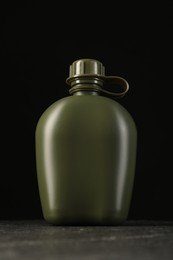 Photo of One green plastic canteen on black table