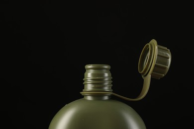 Photo of Green plastic canteen on black background, closeup