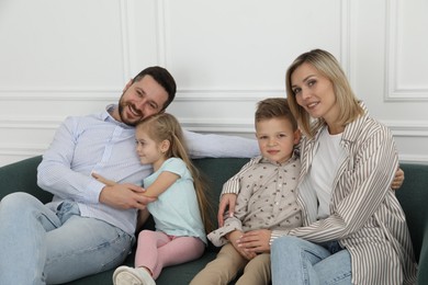 Photo of Happy parents and their children on sofa at home