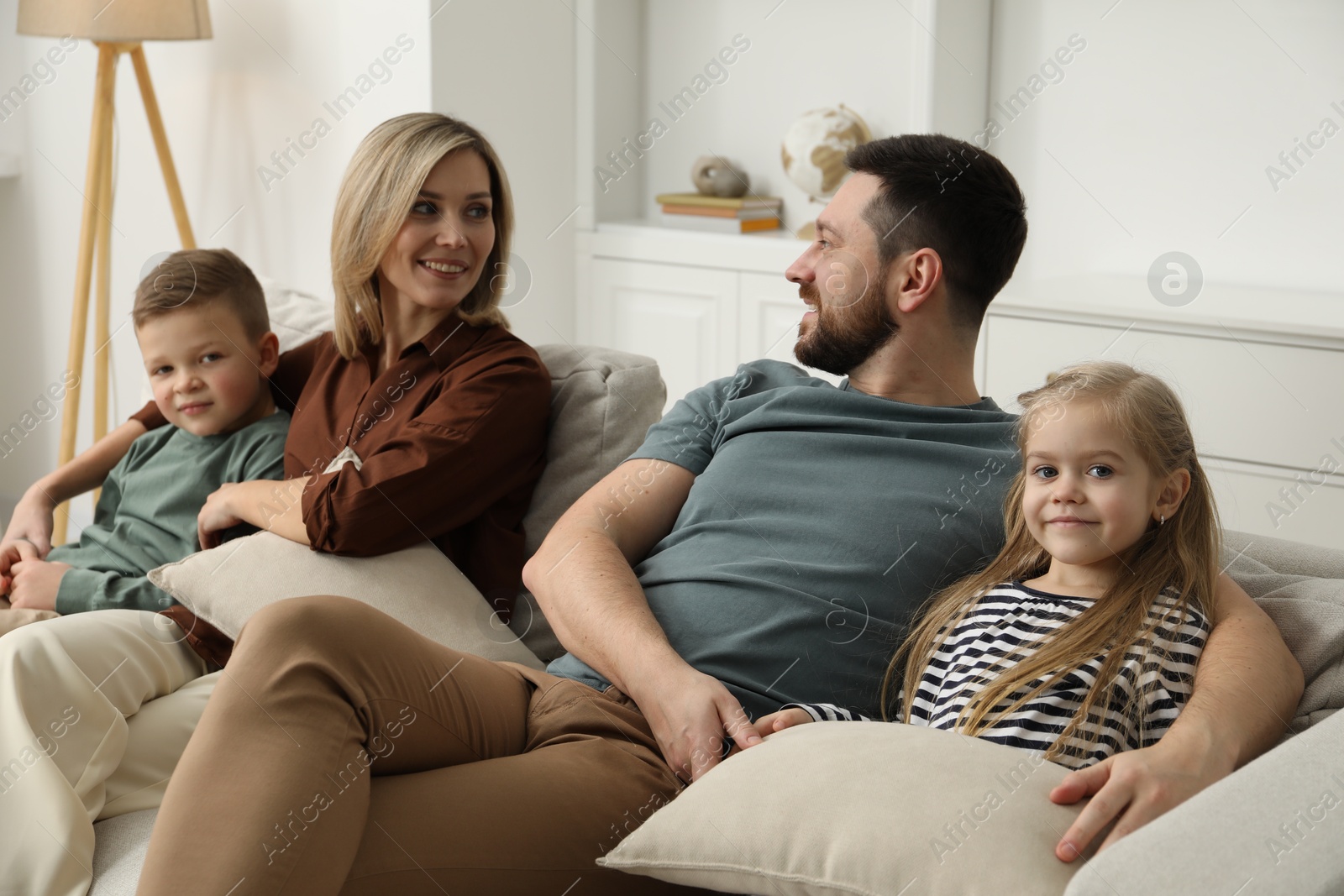 Photo of Happy parents and their children on sofa at home