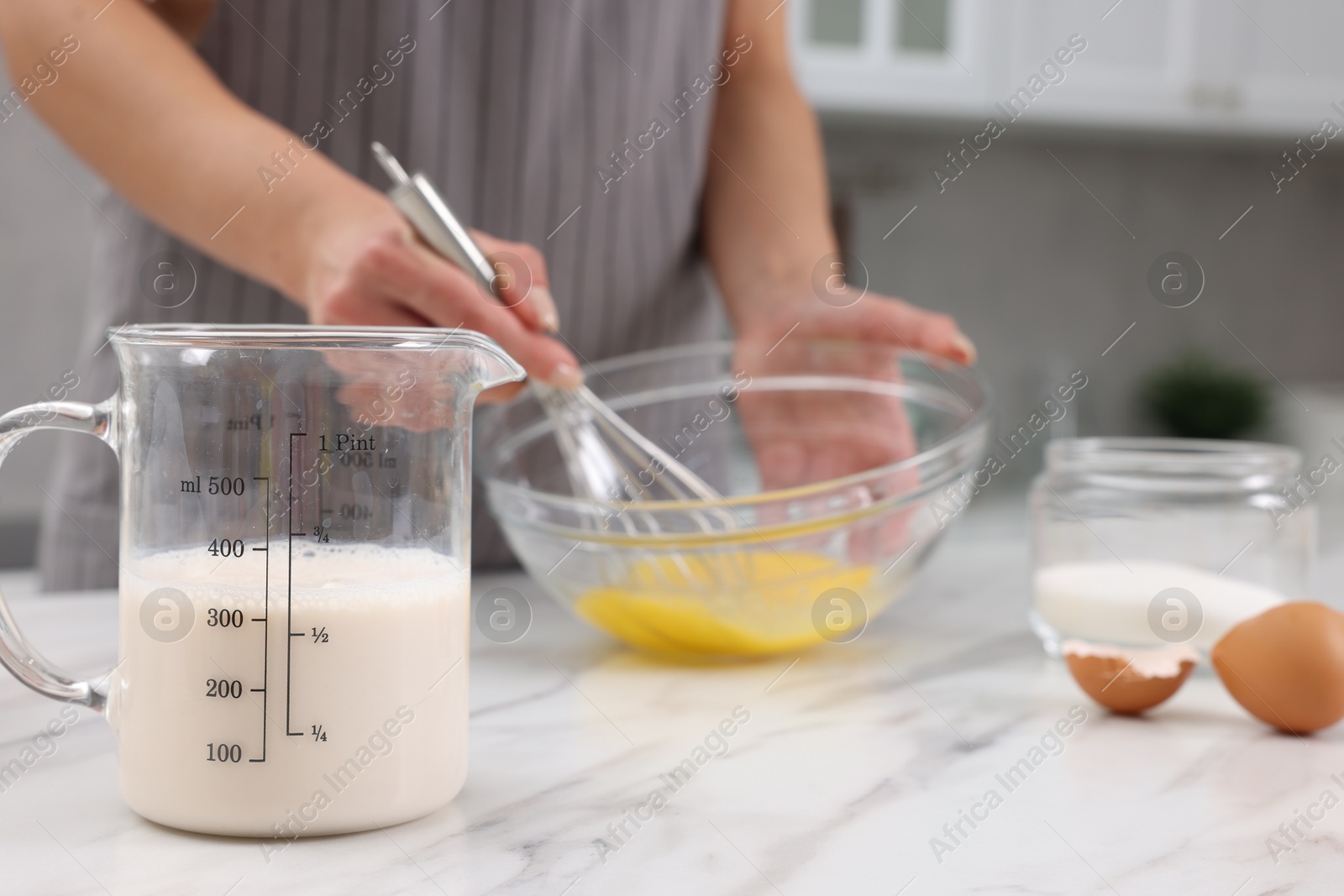 Photo of Woman making dough at white marble table indoors, closeup