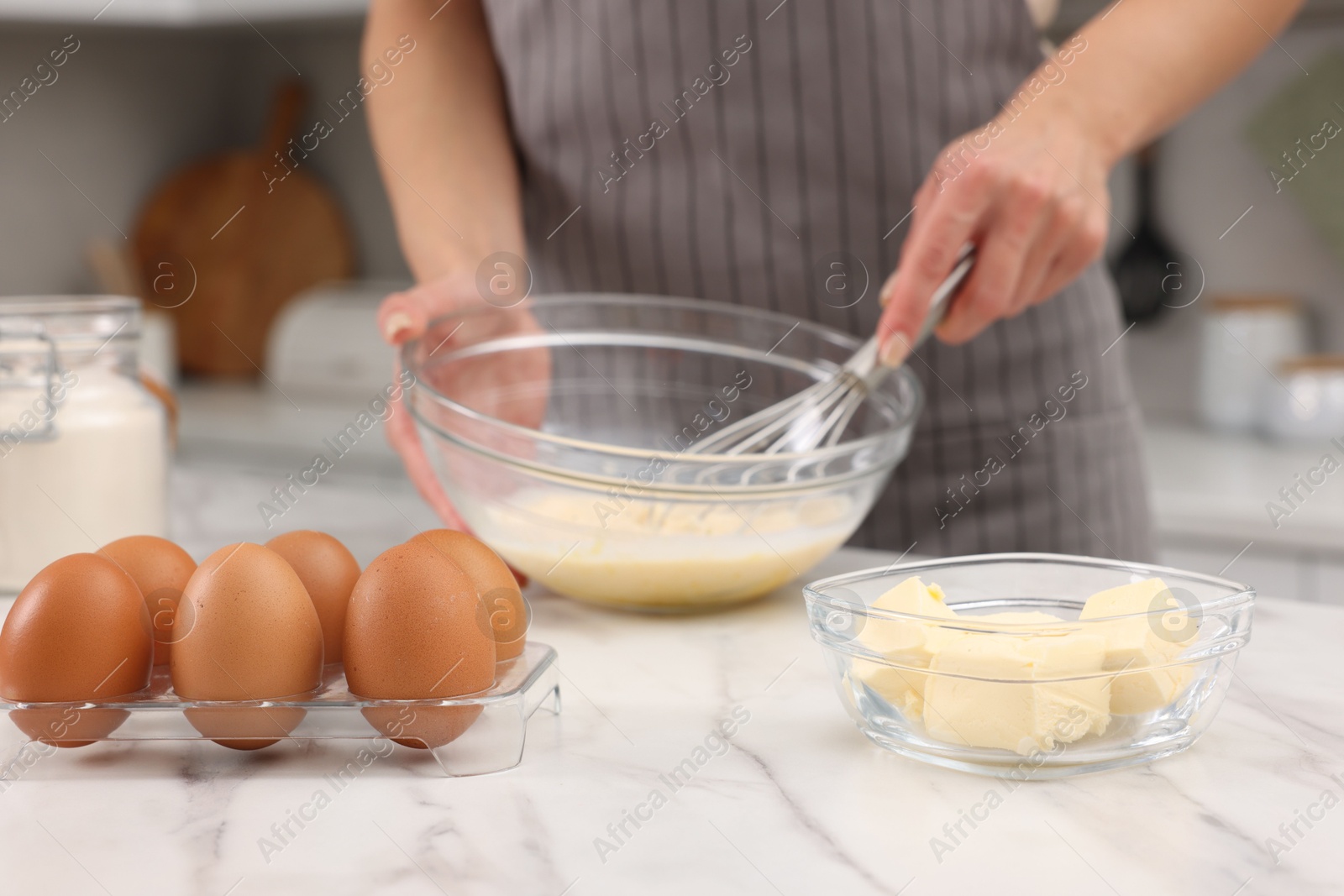 Photo of Woman making dough at white marble table indoors, closeup