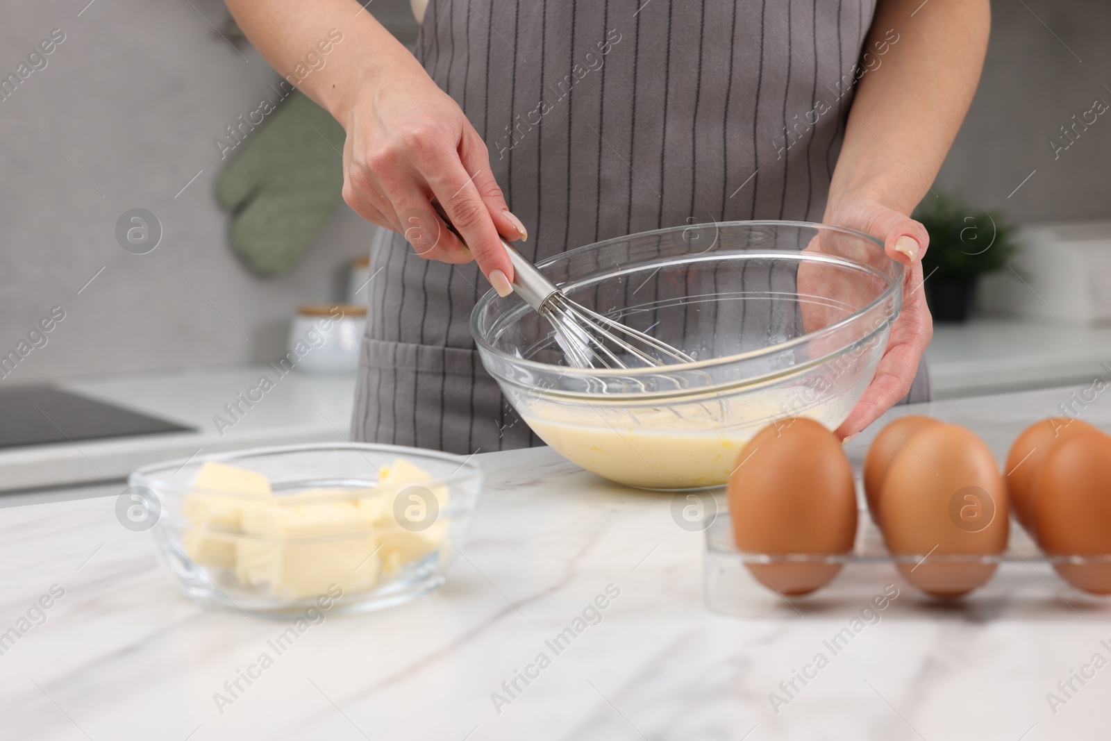 Photo of Woman making dough at white marble table indoors, closeup