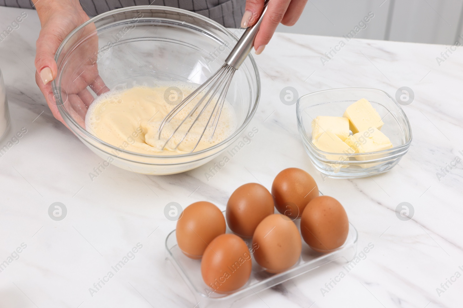 Photo of Woman making dough at white marble table indoors, closeup