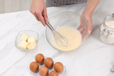 Photo of Woman making dough at white marble table indoors, above view