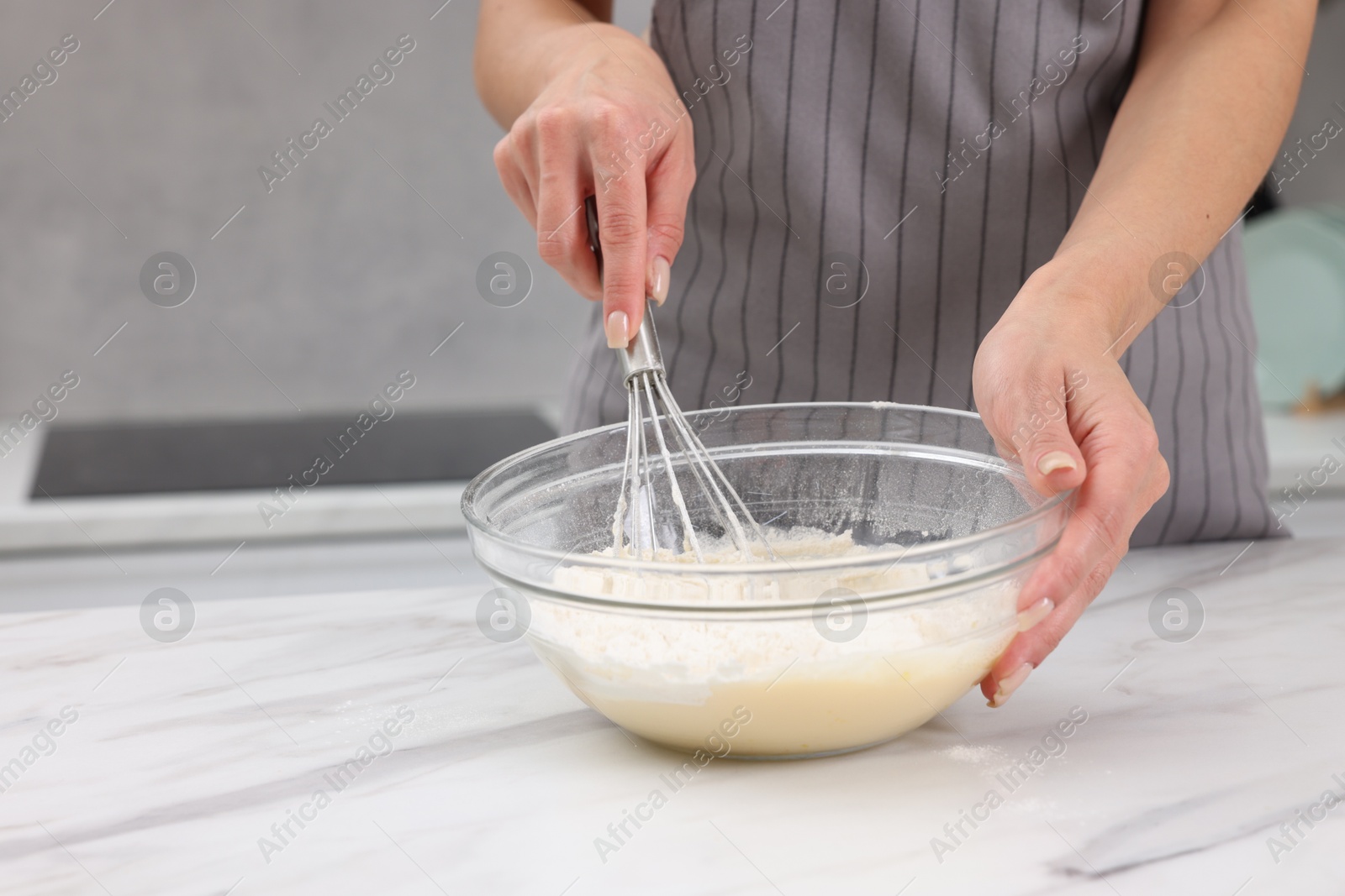 Photo of Woman making dough at white marble table indoors, closeup