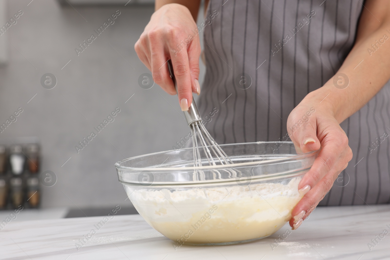 Photo of Woman making dough at white marble table indoors, closeup