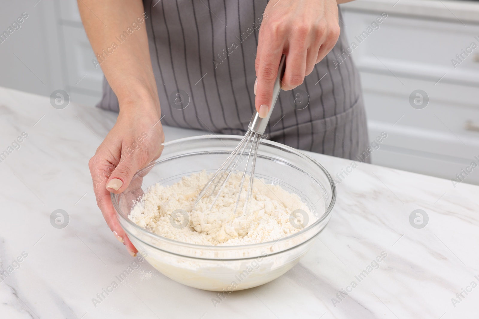 Photo of Woman making dough at white marble table indoors, closeup