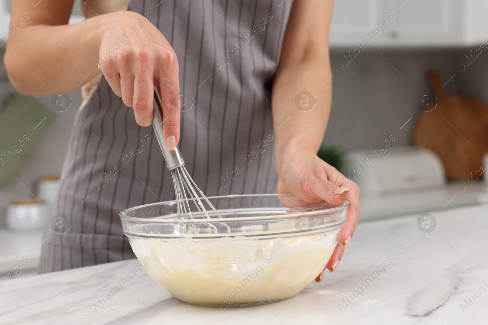 Photo of Woman making dough at white marble table indoors, closeup