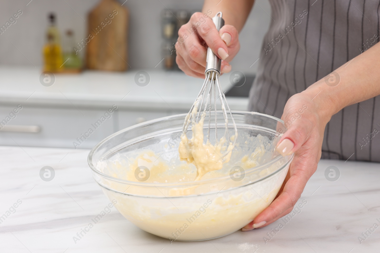 Photo of Woman making dough at white marble table indoors, closeup