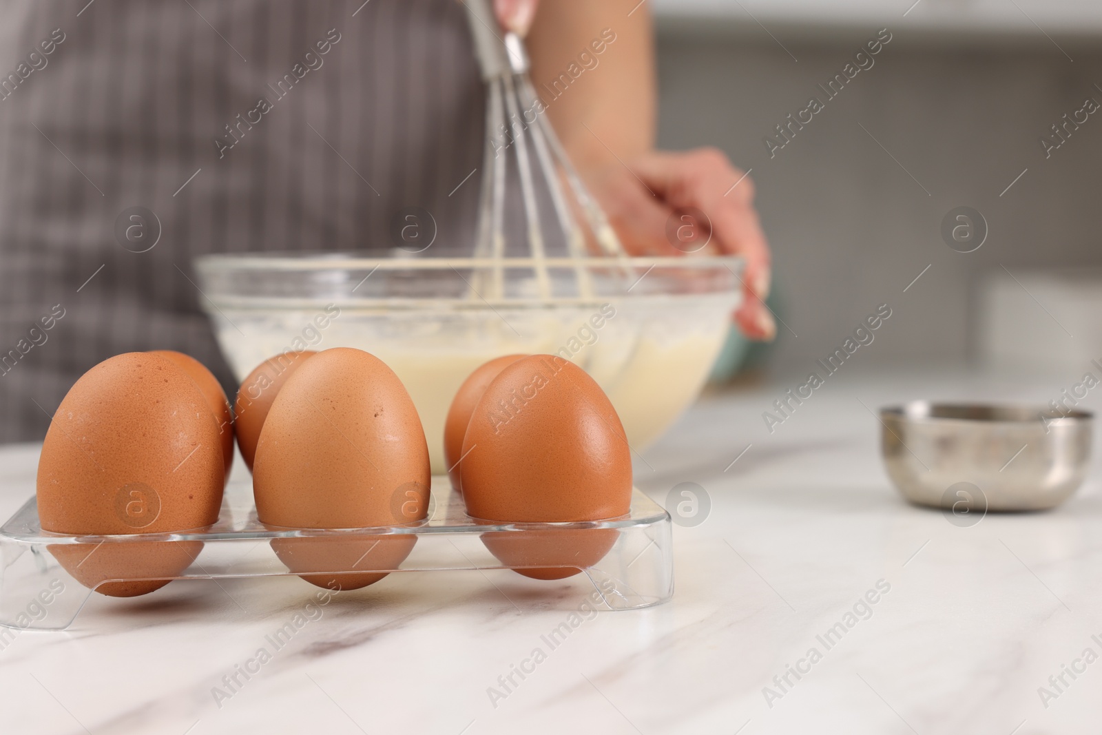 Photo of Woman making dough at white marble table indoors, selective focus