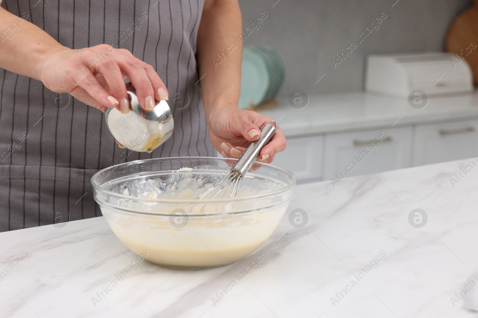 Photo of Woman adding oil into bowl with dough at white marble table, closeup. Space for text