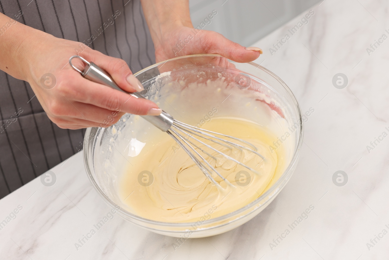 Photo of Woman making dough at white marble table indoors, closeup