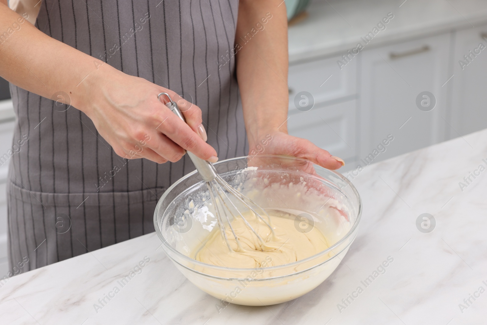 Photo of Woman making dough at white marble table indoors, closeup