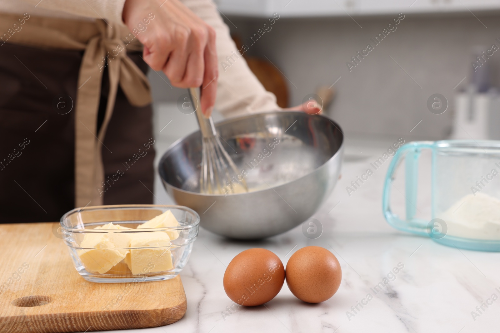 Photo of Woman making dough at white marble table indoors, closeup