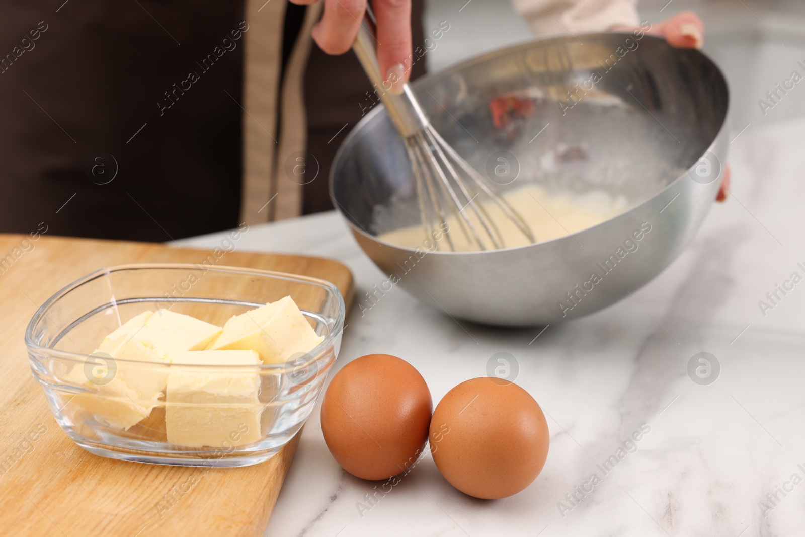 Photo of Woman making dough at white marble table indoors, closeup