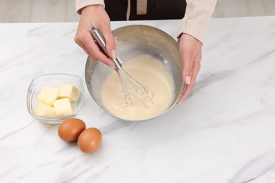 Photo of Woman making dough at white marble table indoors, closeup