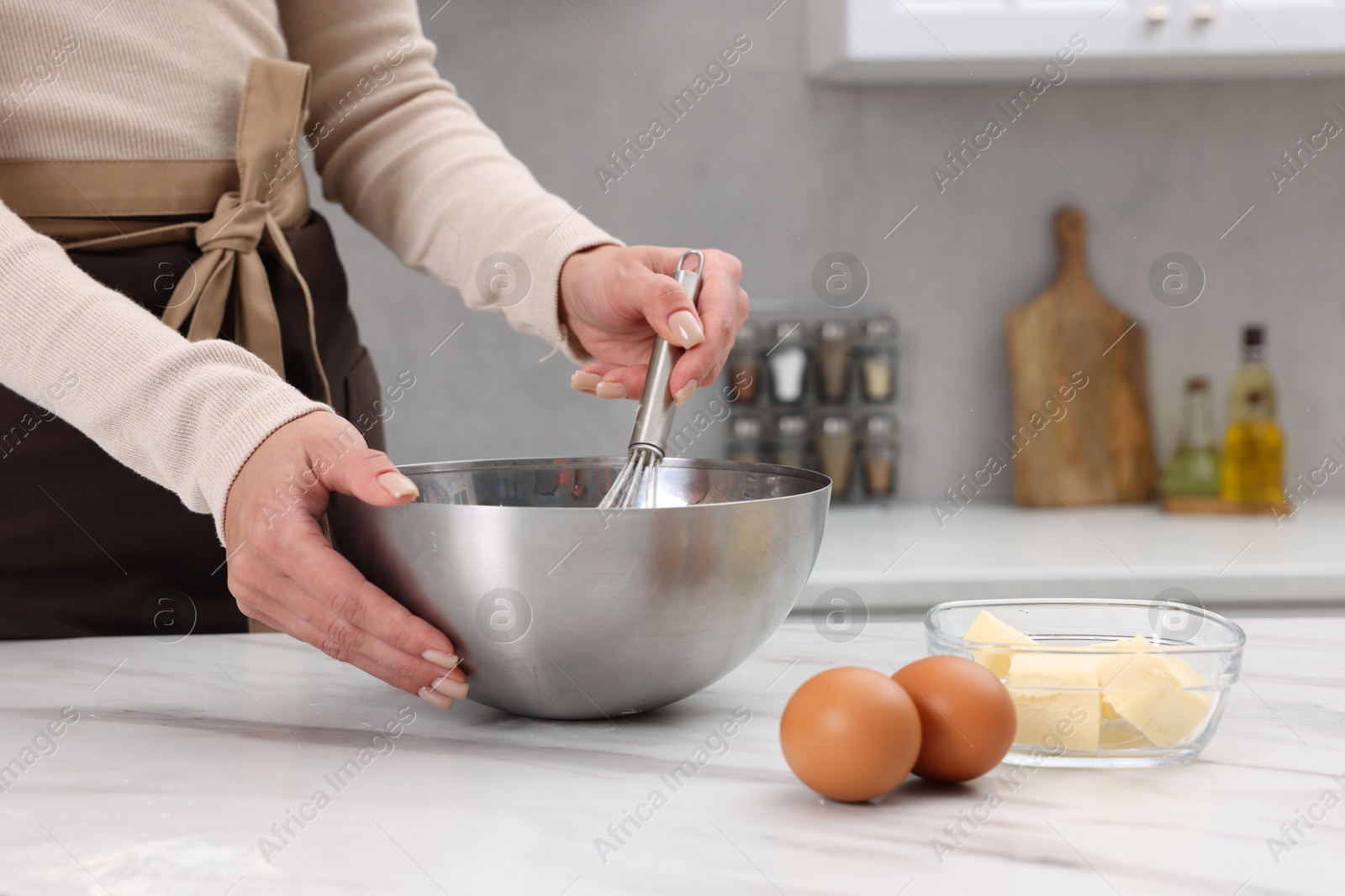 Photo of Woman making dough at white marble table indoors, closeup