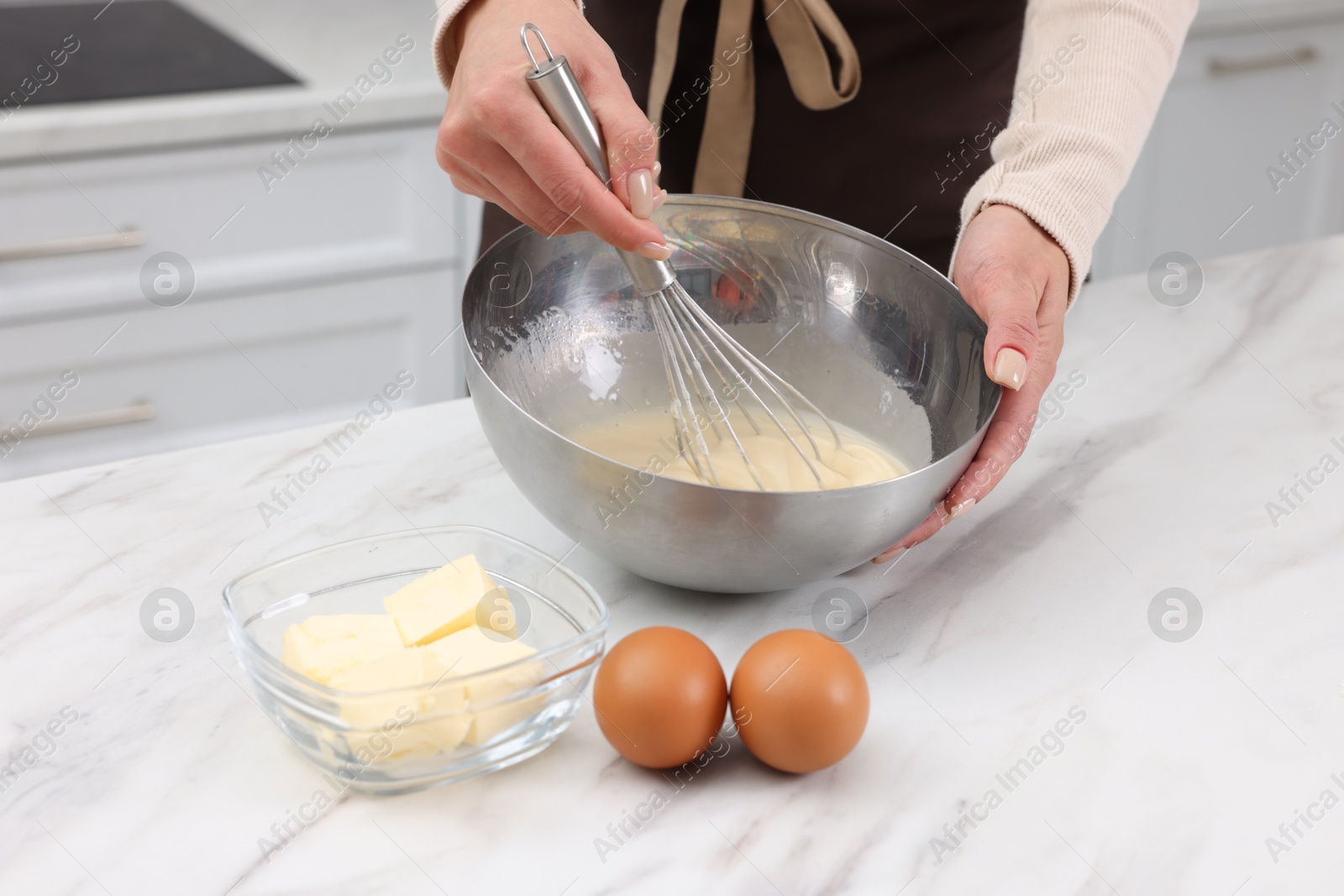 Photo of Woman making dough at white marble table indoors, closeup