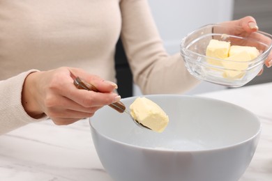 Making dough. Woman adding butter into bowl at white marble table, closeup