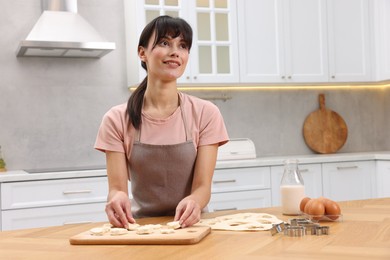 Woman with raw cookies at wooden table