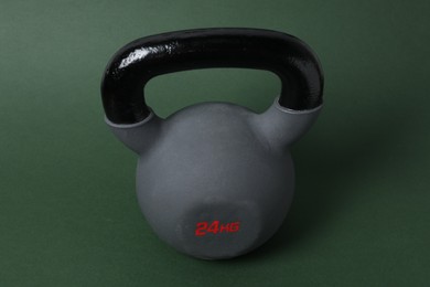 Photo of One kettlebell on dark green background. Sport equipment