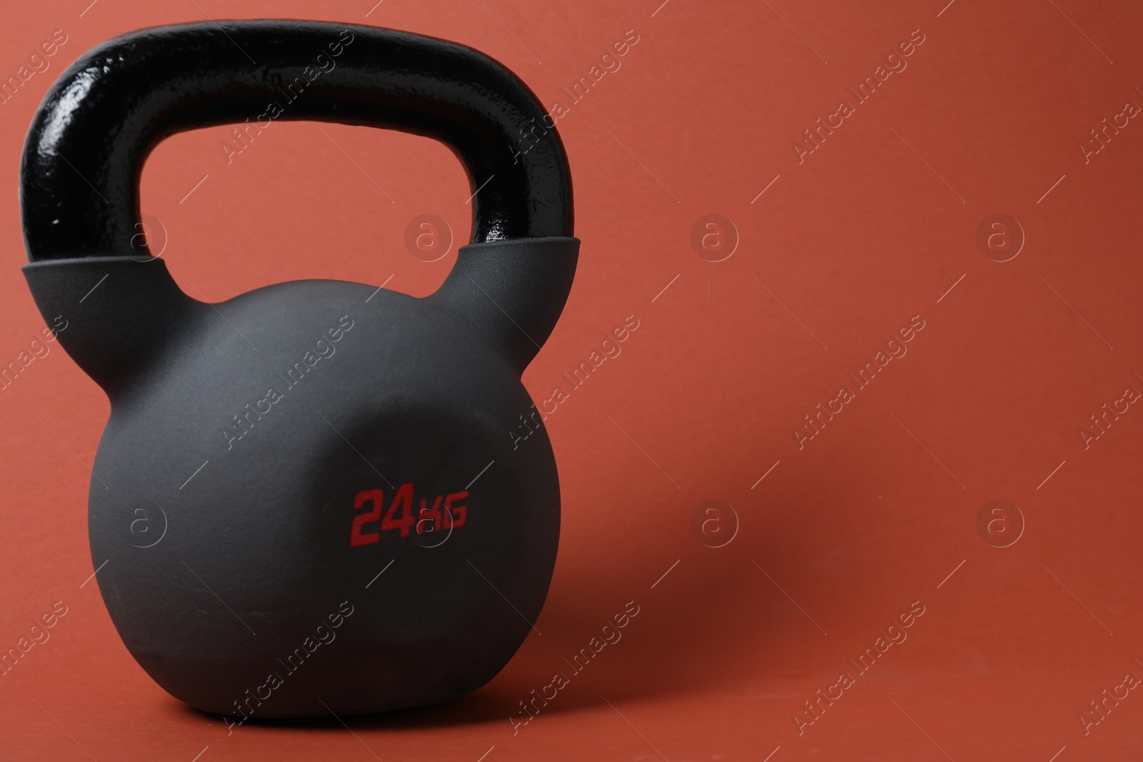 Photo of One kettlebell on orange background. Space for text